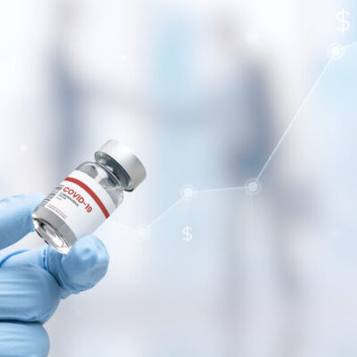 Hand in medical glove holding a vaccine vial Hand in medical glove holding a vaccine vial